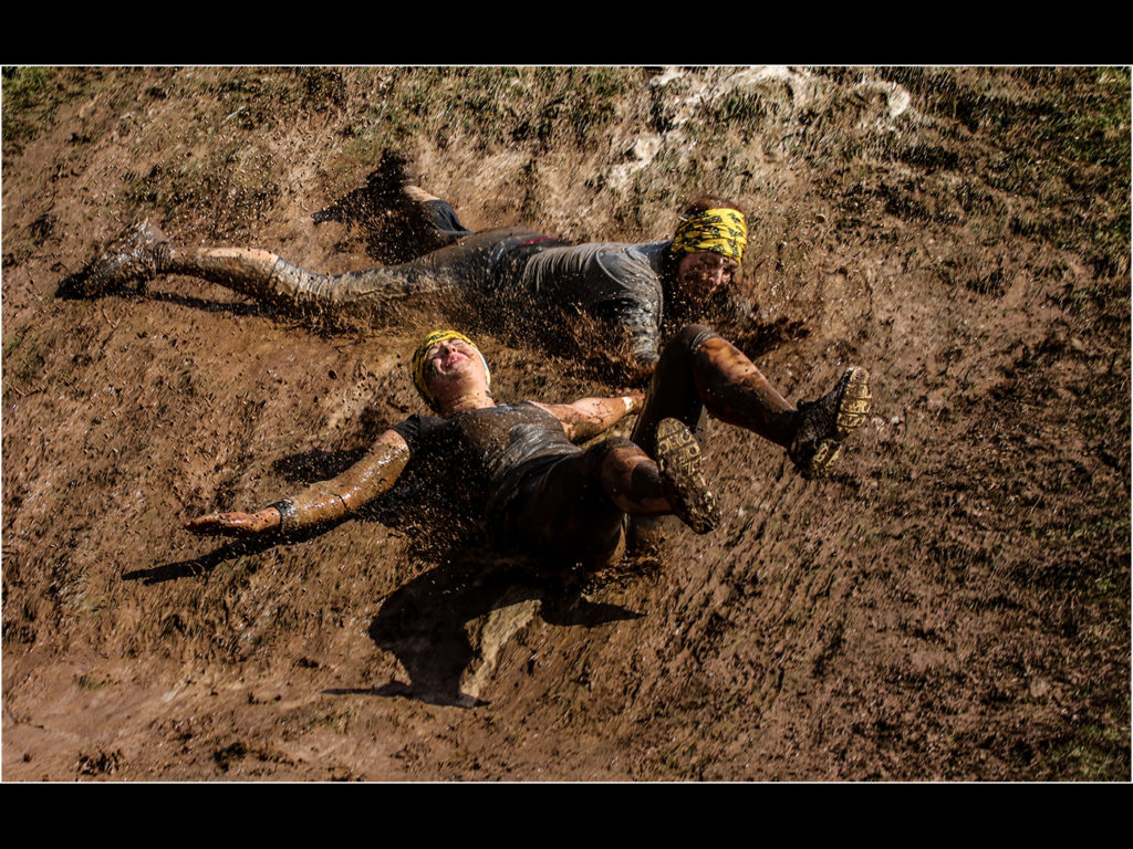 an image showing two people sliding down a wall of mud