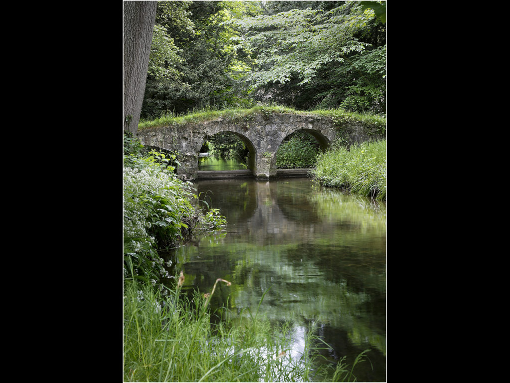 an image of an old stone bridge in a delapidayed state