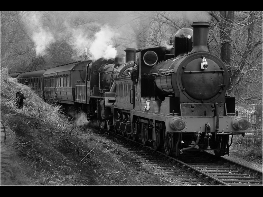 image of two steam trains pulling a rake of coaches